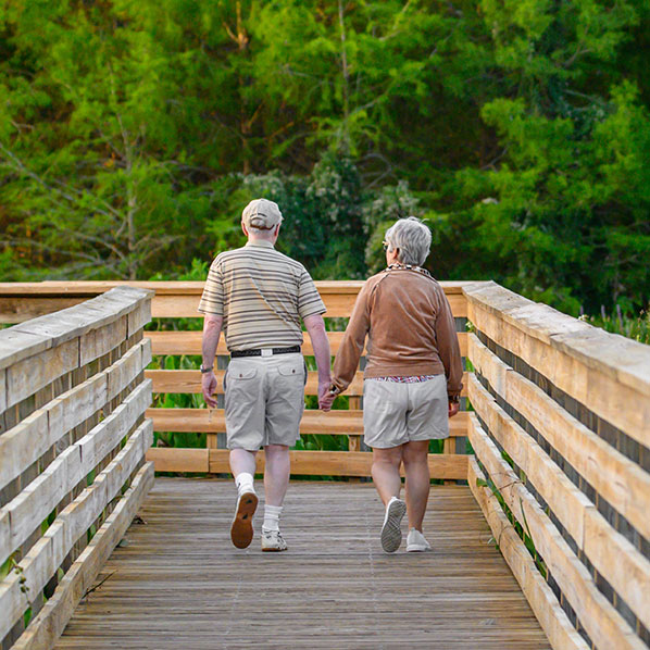 senior couple walking on a boardwalk in a Florida park