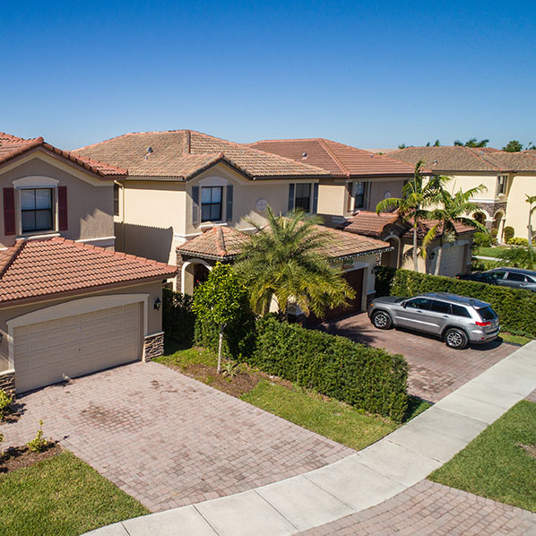 aerial shot of a Florida neighborhood with two-story houses and cars parked in driveways