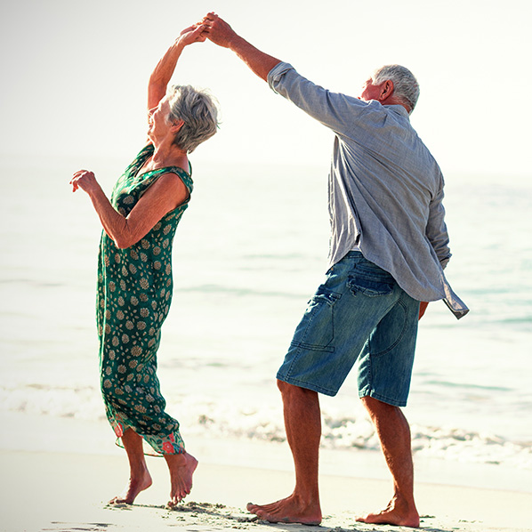 senior couple dancing on the beach